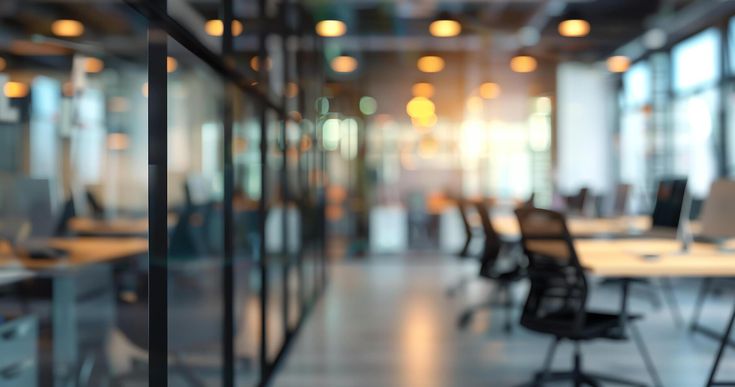 Download AI generated Abstract blurred background of modern office with glass walls shows desks and chairs with computer for free